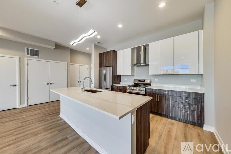 A modern kitchen with wooden floors and white countertops.