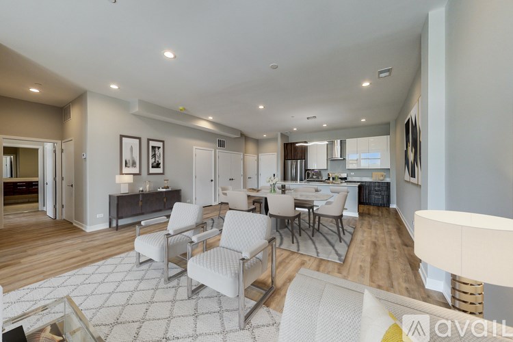 A modern living room with a white sofa set and a wooden floor.