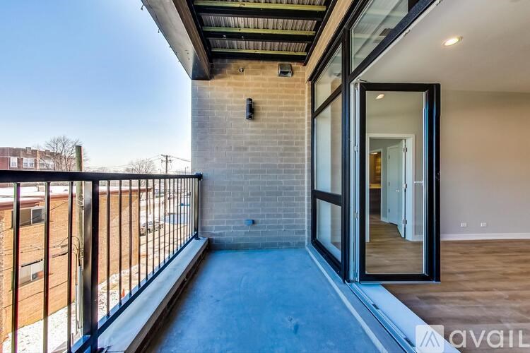 A balcony with a glass door leading to a room.