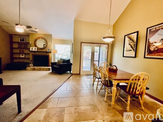 A living room with a fireplace and a dining table.
