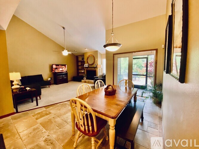 A dining room with a wooden table and chairs.