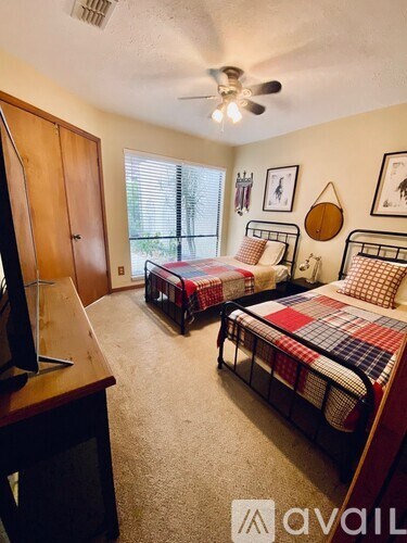 A bedroom with two beds and a television.