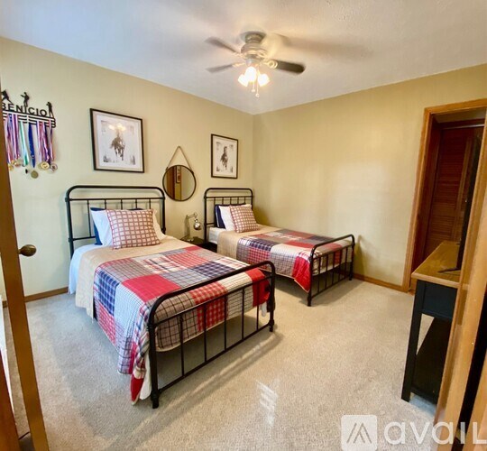 A bedroom with two beds and a ceiling fan.