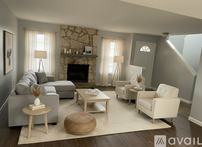 A living room with a grey couch, a white armchair, and a wooden coffee table.