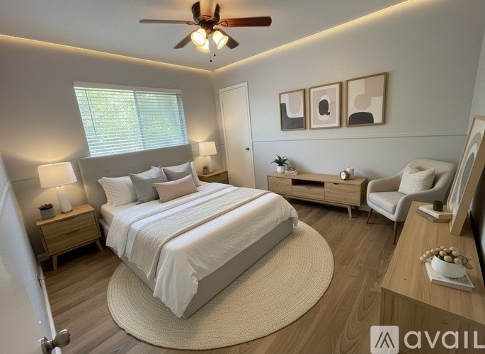A bedroom with a large bed, a ceiling fan, and a chair.