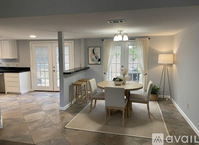 A dining room with a round table and chairs.