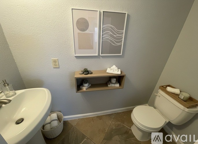 A bathroom with a toilet, sink, and shelf with toiletries.