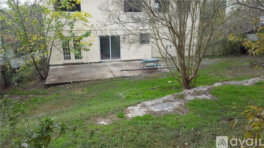 A tree stands in a yard in front of a building.
