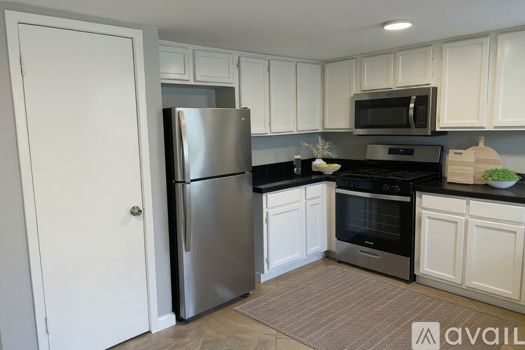 A kitchen with white cabinets and a black countertop.