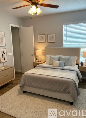 A bedroom with a bed, two lamps, and a ceiling fan.