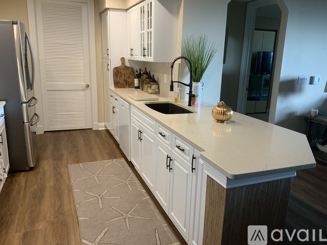A kitchen with white cabinets and a white fridge.
