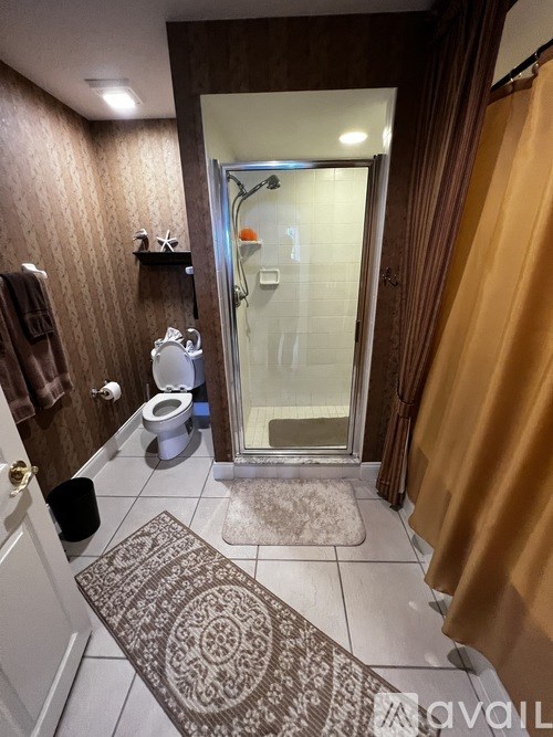 A bathroom with a toilet, sink, and shower.