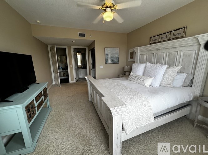 A bedroom with a large bed and a television.