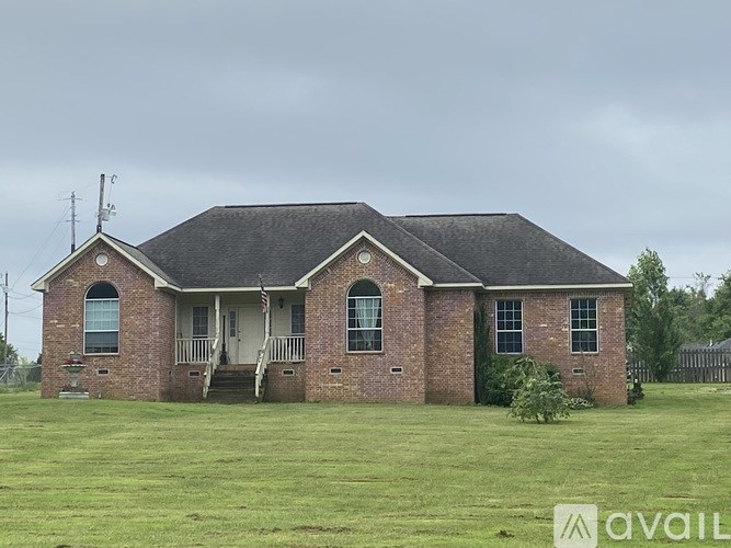 A brick house with a porch and a sign that says "available".