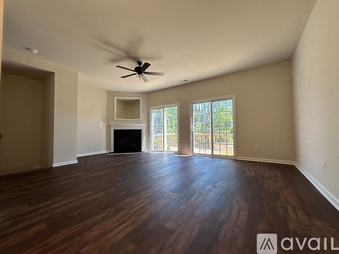 A spacious room with a fireplace and sliding glass doors.