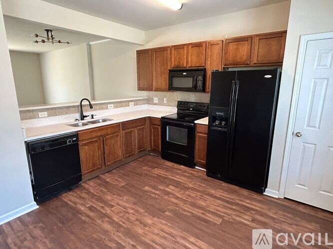 A kitchen with black appliances and wooden cabinets.