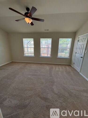 A room with a ceiling fan and carpeted floor.