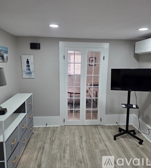 A room with a television and a white cabinet.