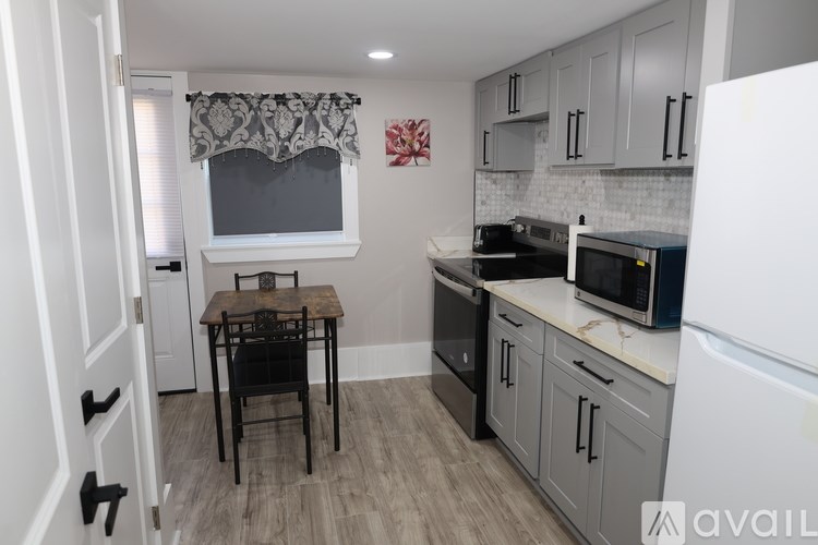 A kitchen with a table and chairs in front of a window.