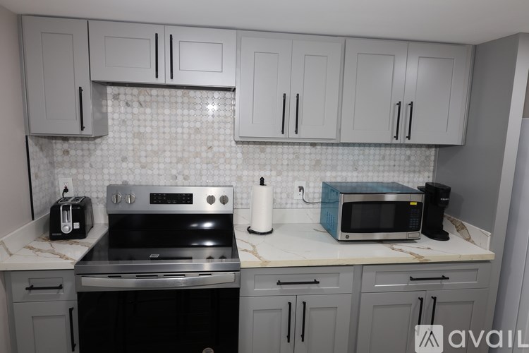 A kitchen with a black stove and white cabinets.