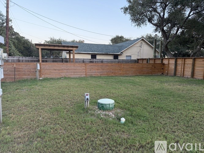 A backyard with a wooden fence and a shed in the background.
