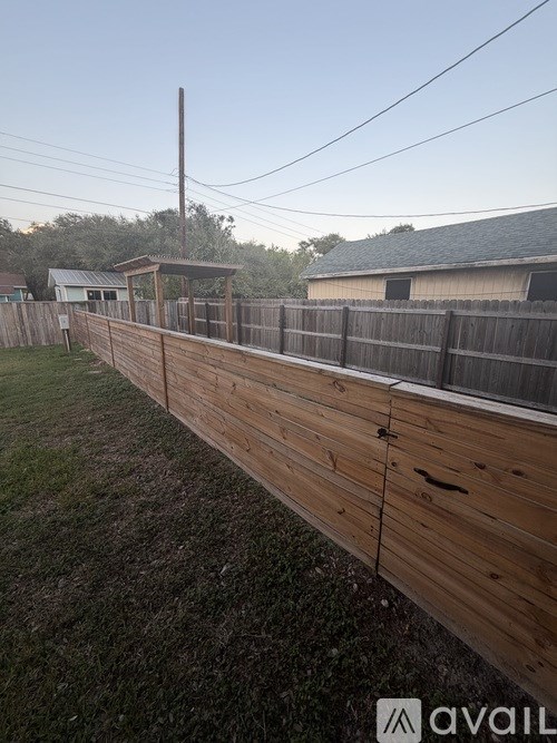 A wooden fence runs along a grassy area.