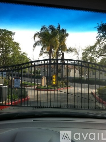 A car is parked in a parking lot with a gate and a sign that says "available".