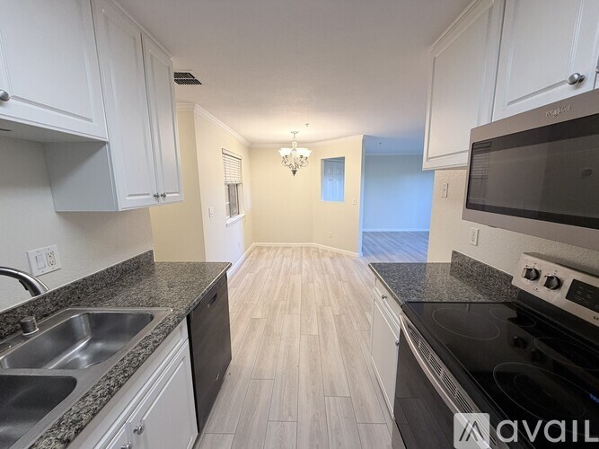 A kitchen with white cabinets and black appliances.