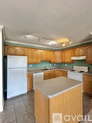 A kitchen with wooden cabinets and a white refrigerator.