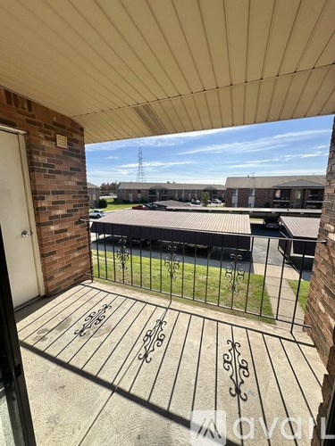 A balcony with a metal railing and a brick wall.