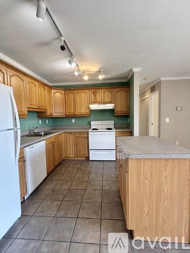 A kitchen with wooden cabinets and a white refrigerator.