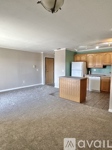 A kitchen area with a white refrigerator and wooden cabinets.