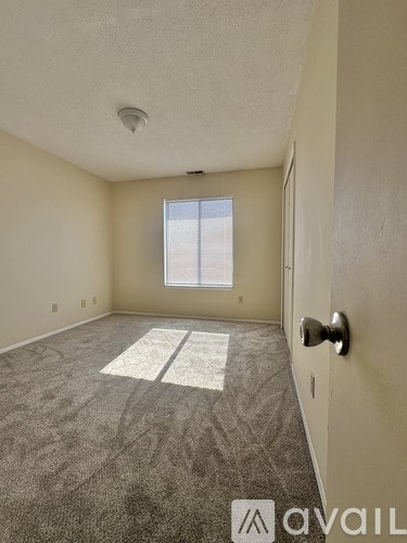 A room with a carpeted floor and a door on the right side.