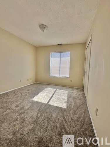 A room with a carpeted floor and a window.