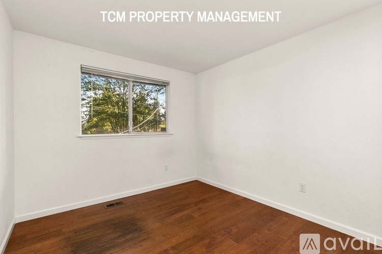 A room with a window showing trees outside.