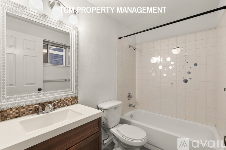 A white bathroom with a sink, toilet, and bathtub.