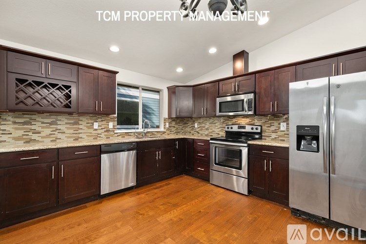 A kitchen with brown cabinets and a white fridge is available for rent.