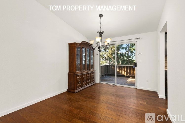 A room with a wooden floor and a chandelier hanging from the ceiling.