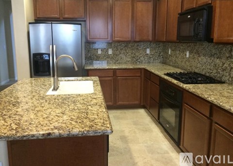 A kitchen with granite countertops and wooden cabinets.