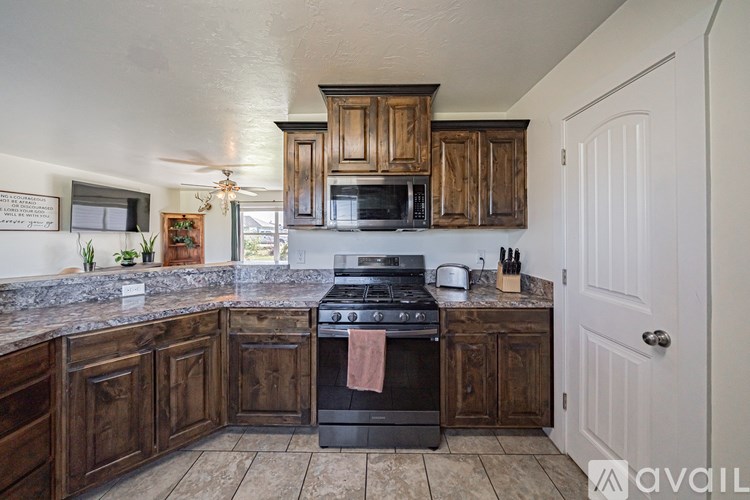 A kitchen with wooden cabinets and a black stove top oven.