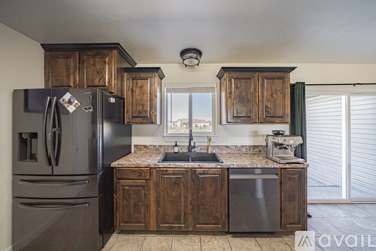 A kitchen with wooden cabinets and a black refrigerator.