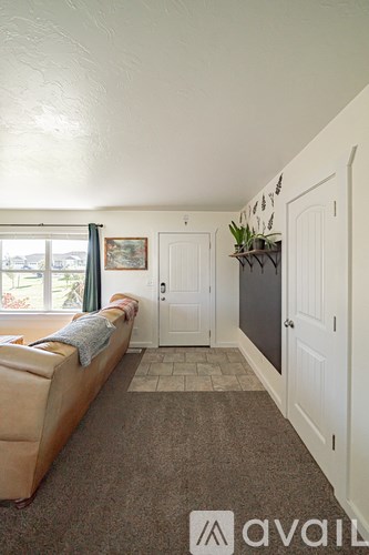 A living room with a couch and a window.