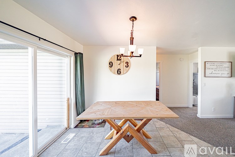 A wooden table with a clock on the wall behind it.