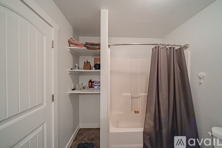 A small bathroom with a shower curtain and a towel rack.