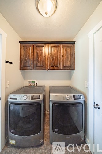 Two ovens sit under a wooden cabinet in a kitchen.