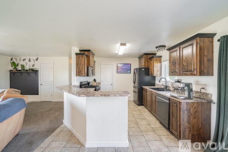 A kitchen with wooden cabinets and a marble island.