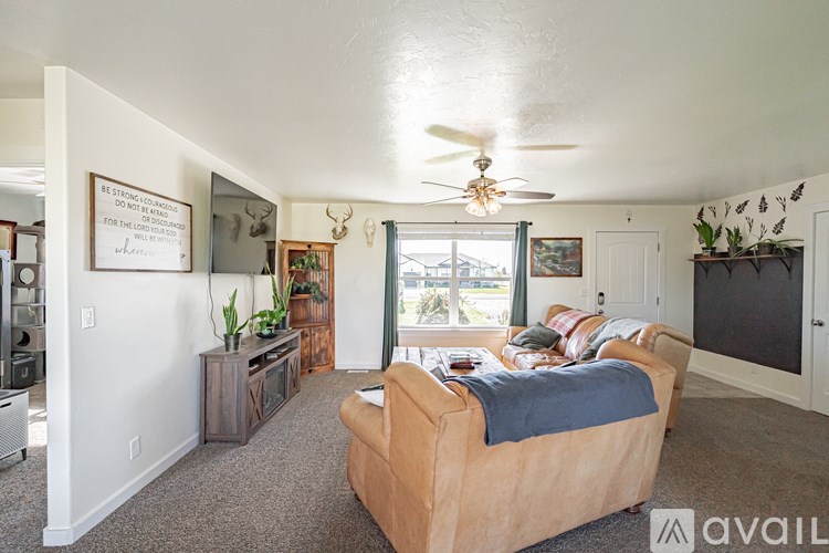 A living room with a couch and a ceiling fan.