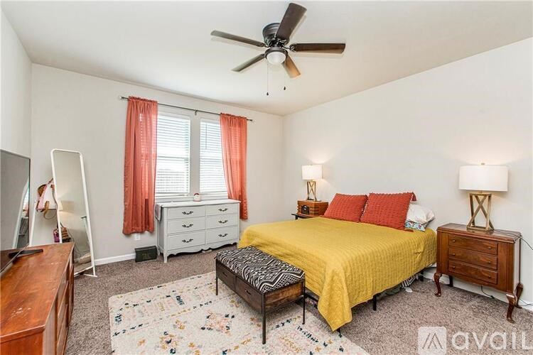 A bedroom with a yellow bed and a wooden dresser.