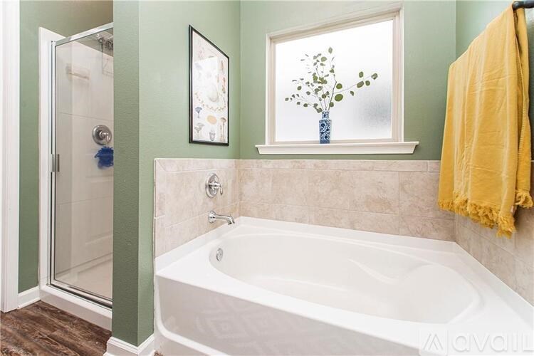 A white bathtub sits in a bathroom with green walls.