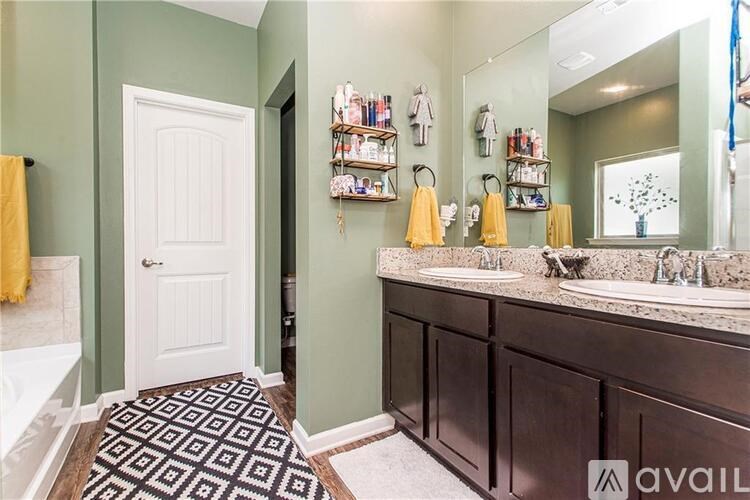 A bathroom with a white door, a mirror, and a sink.